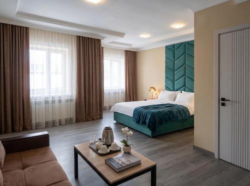a hotel room with a bed and a couch at Avangard Hotel in Almaty