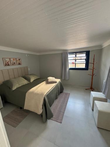 a bedroom with a large bed and a window at Suite Simples PRIVATIVA in Diamantina