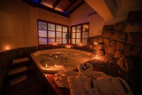 a large bathroom with a tub with candles in it at Hotel San Agustin Urubamba in Urubamba