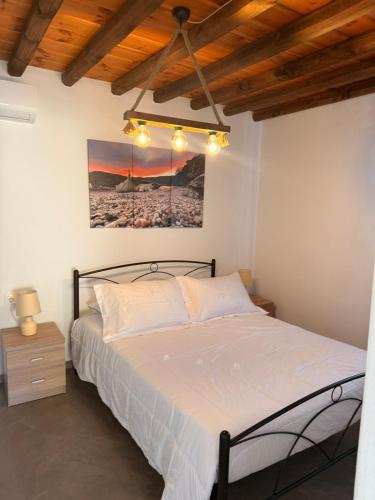 a bedroom with a bed and a painting on the wall at mare Mali Tinos in Mamádhos