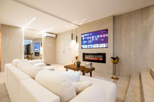 a living room with white furniture and a flat screen tv at Penthouse Centrum Nitra Jacuzzi&View, free parking in Nitra