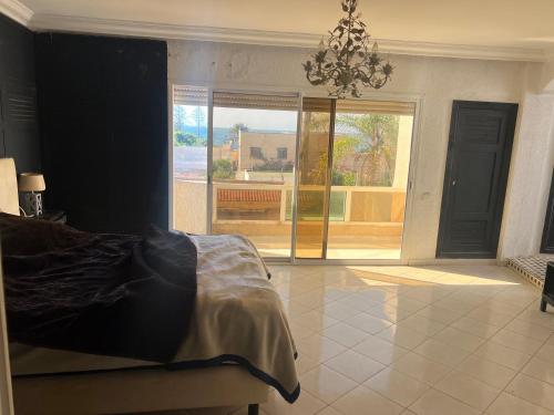a bedroom with a bed and a view of a patio at Villa Tamaris, Dar Bouazza in Tamaris