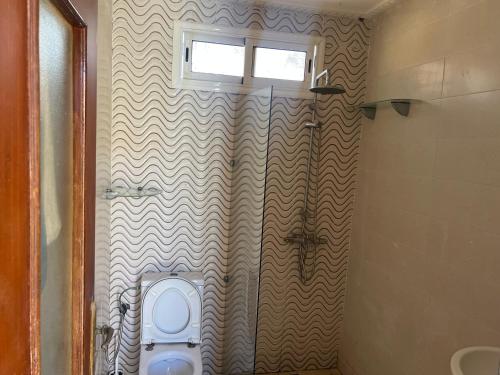 a bathroom with a toilet and a window at Villa Tamaris, Dar Bouazza in Tamaris