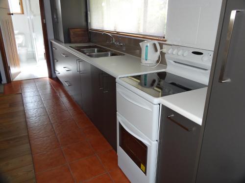 a kitchen with a white stove top oven next to a sink at Mapperley Bed and Breakfast in Bordertown
