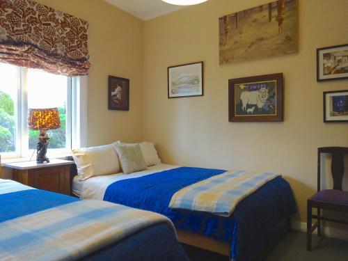 1 dormitorio con 2 camas y ventana en Muddy Creek Cutting, en Lauder