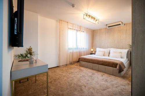 a bedroom with a bed and a desk and a window at Penthouse Centrum Nitra Jacuzzi&View, free parking in Nitra