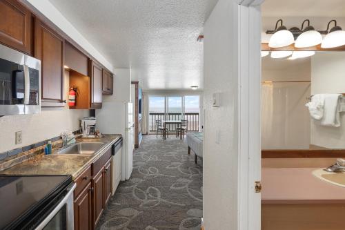 a kitchen with a sink and a living room at Surfside Resort in Rockaway Beach