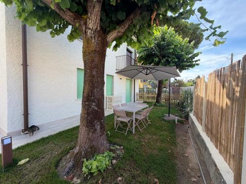a table and chair under a tree in a yard at Casa Arianna in Lido di Camaiore