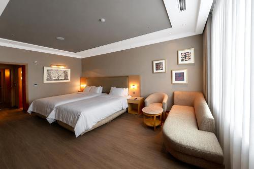 a hotel room with a bed and two chairs at Daegu Grand Hotel in Daegu
