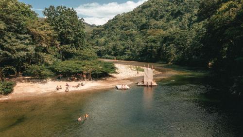 a group of people in the water on a beach at Rio Hostel Buritaca in Buritaca