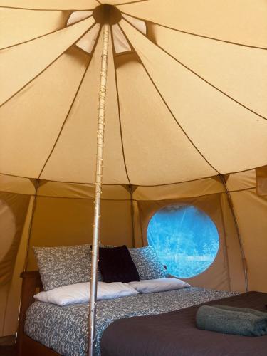 a tent with two beds in it with a window at Sora Bell Tent in Coxwold