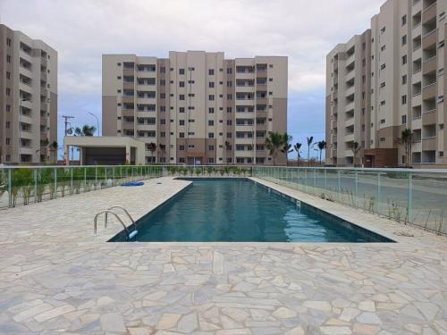 a swimming pool in a building with two tall buildings at Brisa do mar região dos lagos in São Pedro da Aldeia