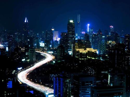 a city lit up at night with cars at Pullman Shanghai Central in Shanghai