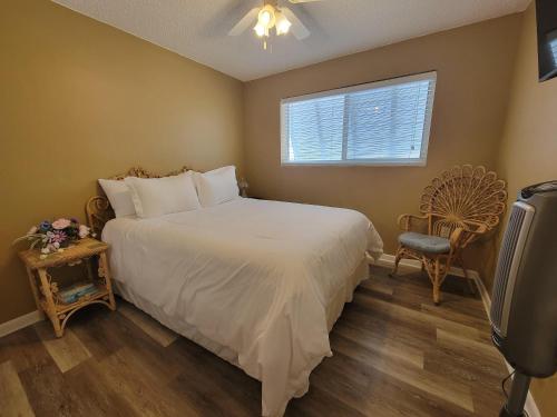 a bedroom with a bed and a window and a chair at Blue Gem in Key West