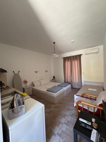 a living room with two beds and a couch at Vista del Mare Rooms 1 in Agios Ioannis Kaspaka