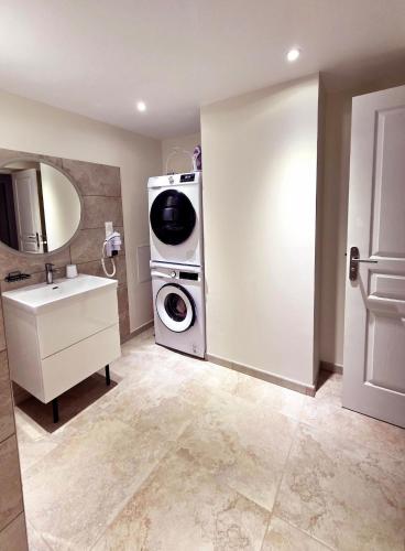 a bathroom with a washing machine and a washer and dryer at L'écrin d'Hélène in Lormes