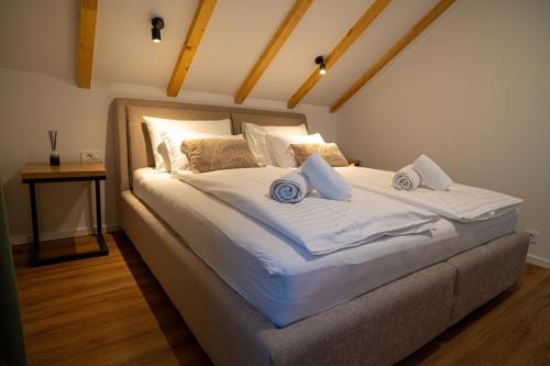 a bedroom with a large bed with white sheets and pillows at Holiday Home Ari in Lički Ribnik