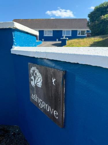 a sign on a blue wall in front of a house at Ashgrove, Kinsale in Kinsale