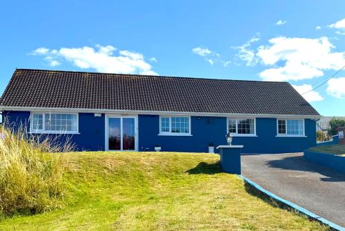a blue house sitting on top of a yard at Ashgrove, Kinsale in Kinsale