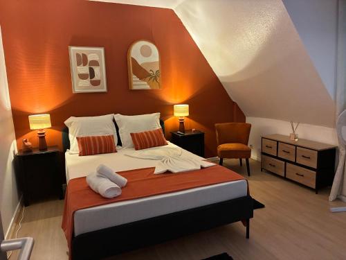a bedroom with a large bed with orange walls at Studio Centre Strasbourg in Strasbourg