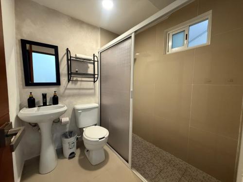 a bathroom with a toilet and a sink and a shower at Casa Villa Leo in Cancún