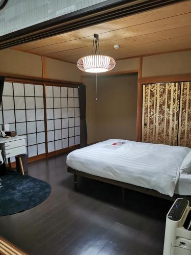 a bedroom with a bed and a desk and a chandelier at Villa9 in Onjuku