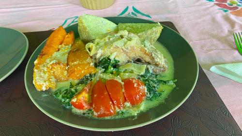 a plate of food with vegetables and fruit on a table at Nukuwasiga homestay in Soso