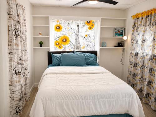 a bedroom with a bed and a window with sunflowers at The orlando oasis in Orlando