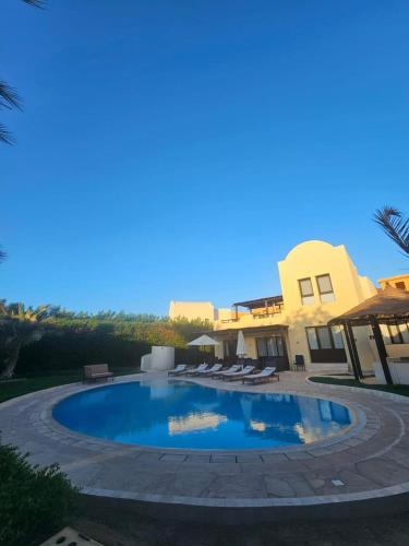 a swimming pool in front of a house at Private Villa Heated Pool & Enclosed Garden in Hurghada