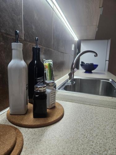 a kitchen counter with two bottles and a sink at Seven Plus in Filiatra