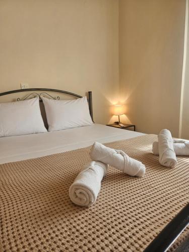 two rolled towels on a bed in a bedroom at Seven Plus in Filiatra