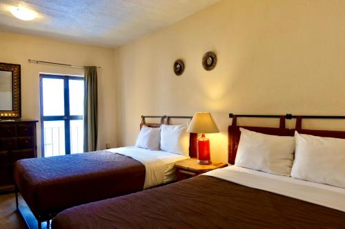a hotel room with two beds and a window at Balcones de Galarza 24 in Guanajuato