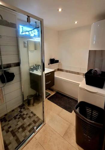a bathroom with a shower and a tub and a sink at La Ch'tite Maison in Masnières