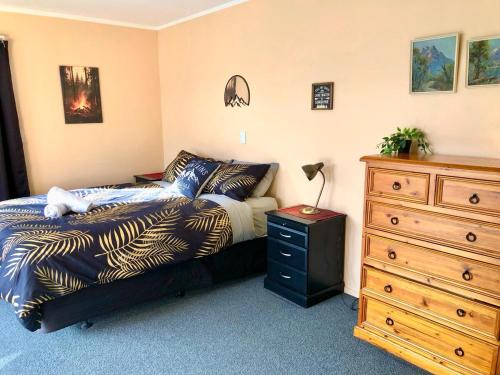 a bedroom with a bed and a dresser at The Shed in Manapouri