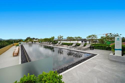 a swimming pool with lounge chairs on a building at Seashore Beach Residences by NLA in Bang Tao Beach