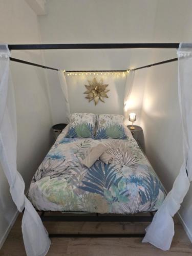 a bed with a canopy in a room at Le Club Philibert in Auxerre