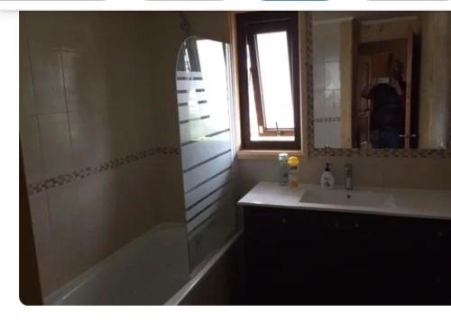 a bathroom with a shower and a sink and a mirror at Casa Monita in El Quisco