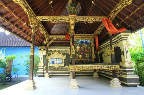 a temple with a bench in front of a building at Ryanbagus Guest House in Canggu