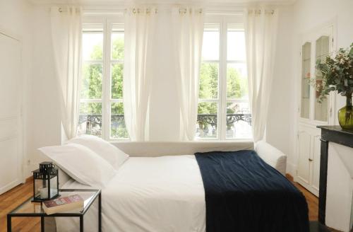 a white bedroom with a bed and a window at C34-Panorama in Chantilly
