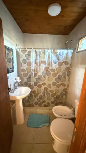 a bathroom with a sink and a toilet and a shower curtain at Posada La Martina in Goya
