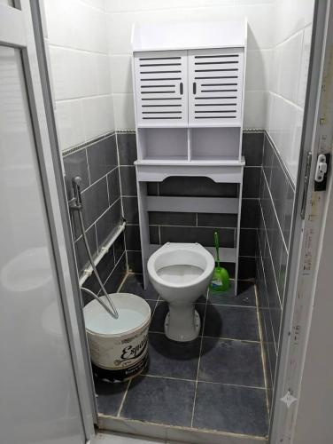 a small bathroom with a toilet and a bucket at Dar mouni relax in Oran