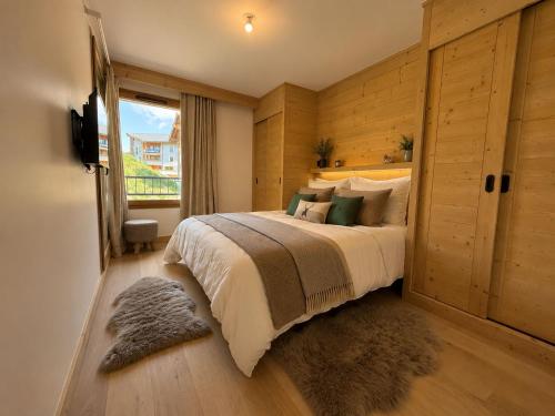 a bedroom with a large bed and a window at Résidence Phoenix C by Leavetown Vacations in L'Alpe-d'Huez