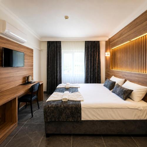 a hotel room with a bed and a desk at Pamukkale Cleopatra in Pamukkale