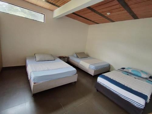 a room with three beds in a room at Casa en el campo - villeta in Villeta