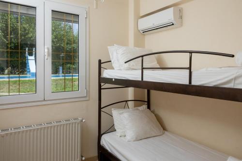 a bedroom with two bunk beds and a window at Zeusplace Anamesa Pool Villa in Litochoro