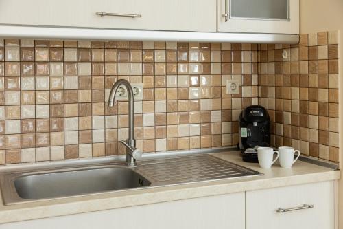 a kitchen sink with two white cups on the counter at Zeusplace Anamesa Pool Villa in Litochoro