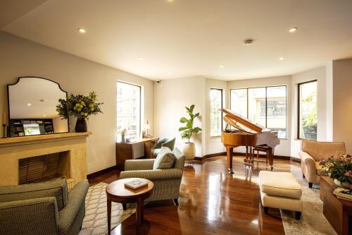 a living room with a fireplace and a piano at Hotel bh La Quinta in Bogotá