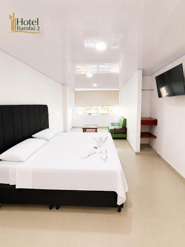 a bedroom with a white bed and a tv at Hotel Bambù 2 in Puerto Asís