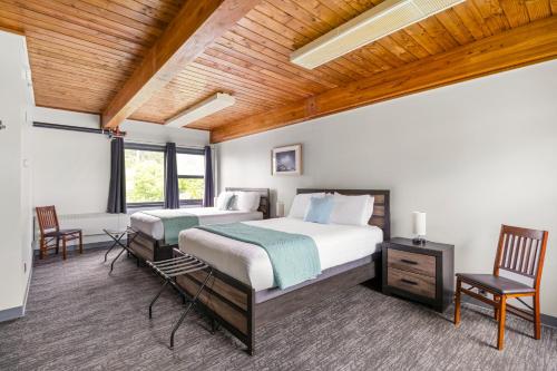a bedroom with two beds and a wooden ceiling at Seward Adventure Lodge in Seward