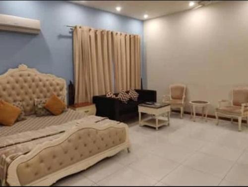 a bedroom with a bed and a living room at Comfort Guest House in Karachi